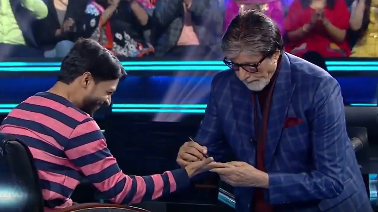 Amitabh signs on contestant's hand Amitabh signs on contestant's hand