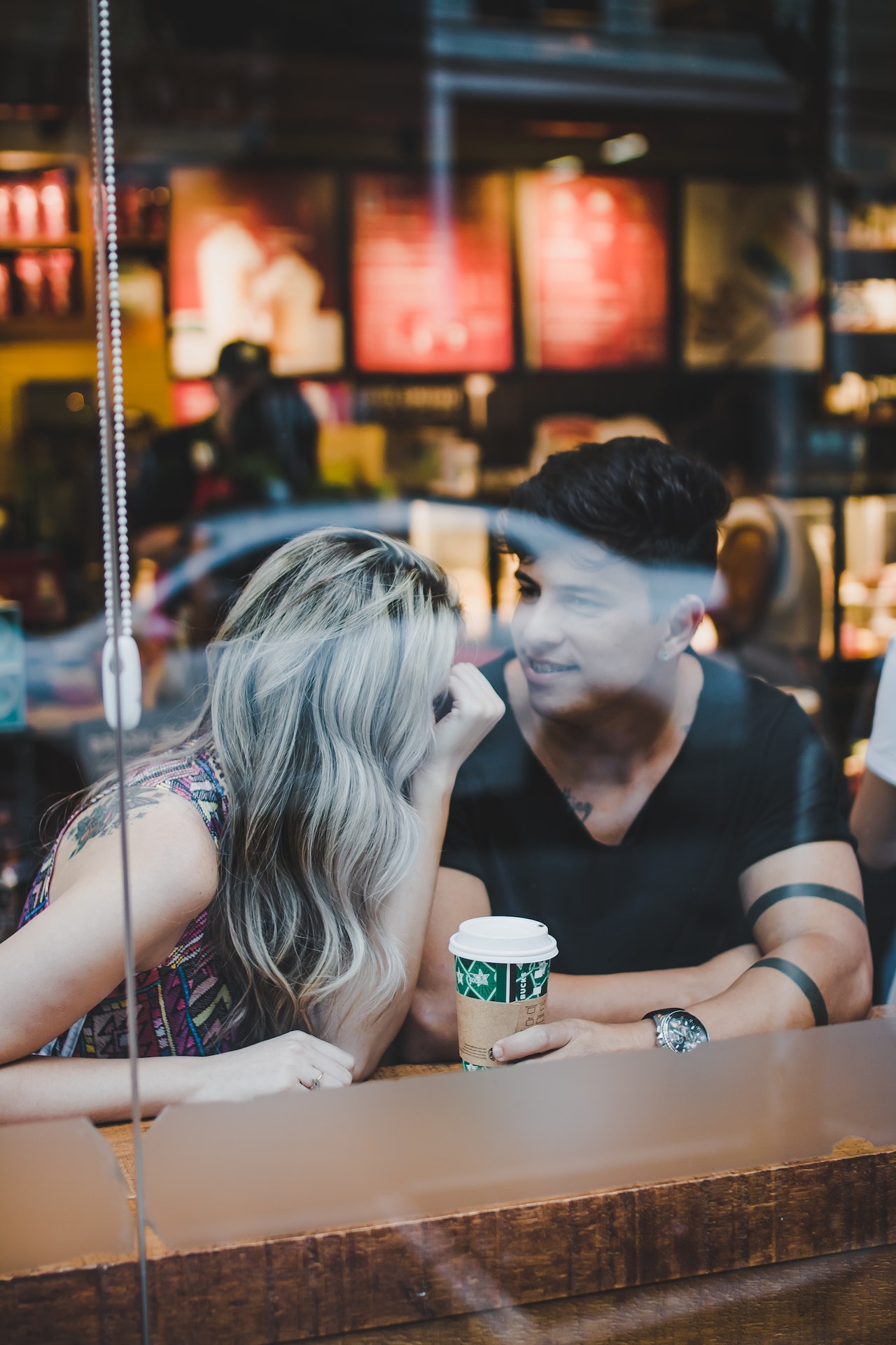 A couple sitting at a coffee shop discussing the highlights of their day for a late night date