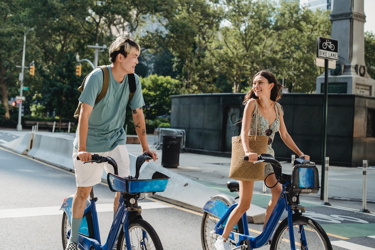 A teen couple riding a bicycle together for a date