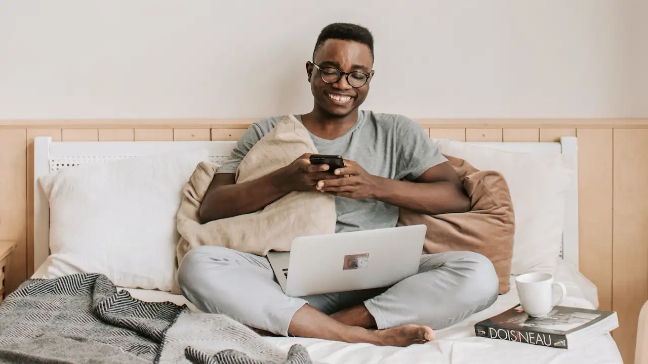 Man Sitting on Bed While Playing Texting Games