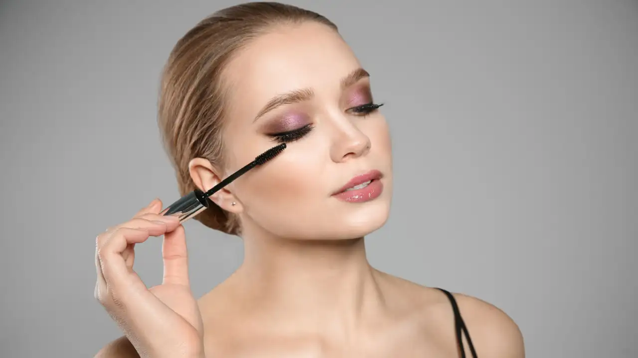 A woman using one of the Best Drugstore Tubing Mascaras to Dramatize Your Eyes