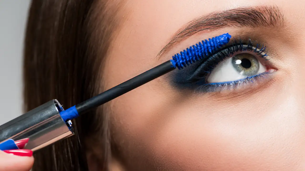 A woman applying one of the Best Blue Mascaras You Need to Spruce up Your Eye Makeup