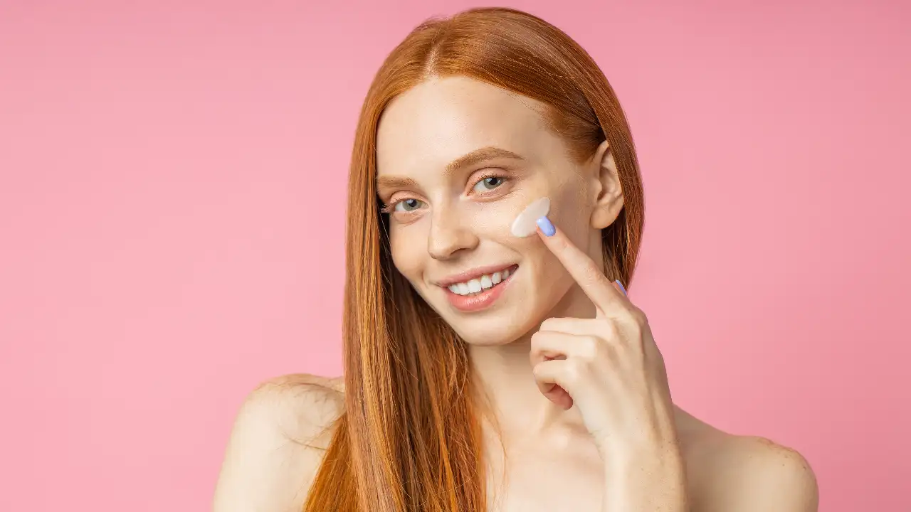 A woman applying the Best Drugstore Primers for Oily Skin And a Smooth Canvas