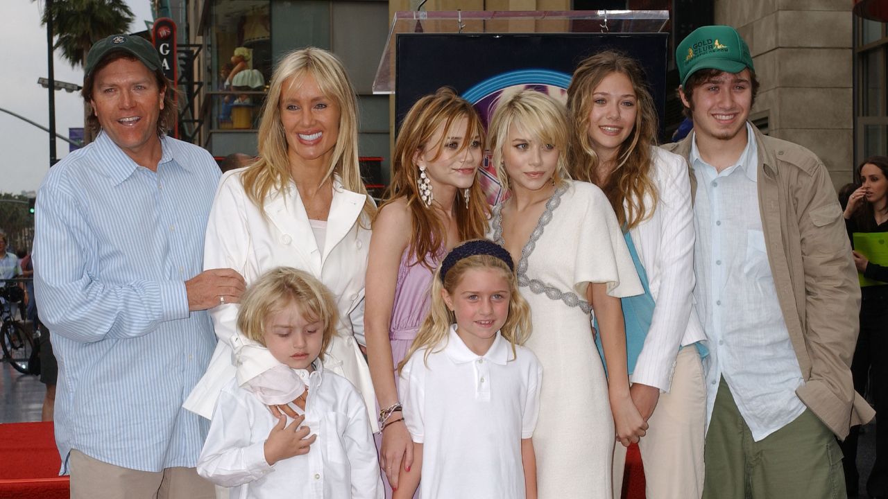Mary-Kate Olsen and Ashley Olsen with dad David (left), step mom MacKenzie, Jake and Taylor (front), sister Lizzie and brother Trent (Getty Images)