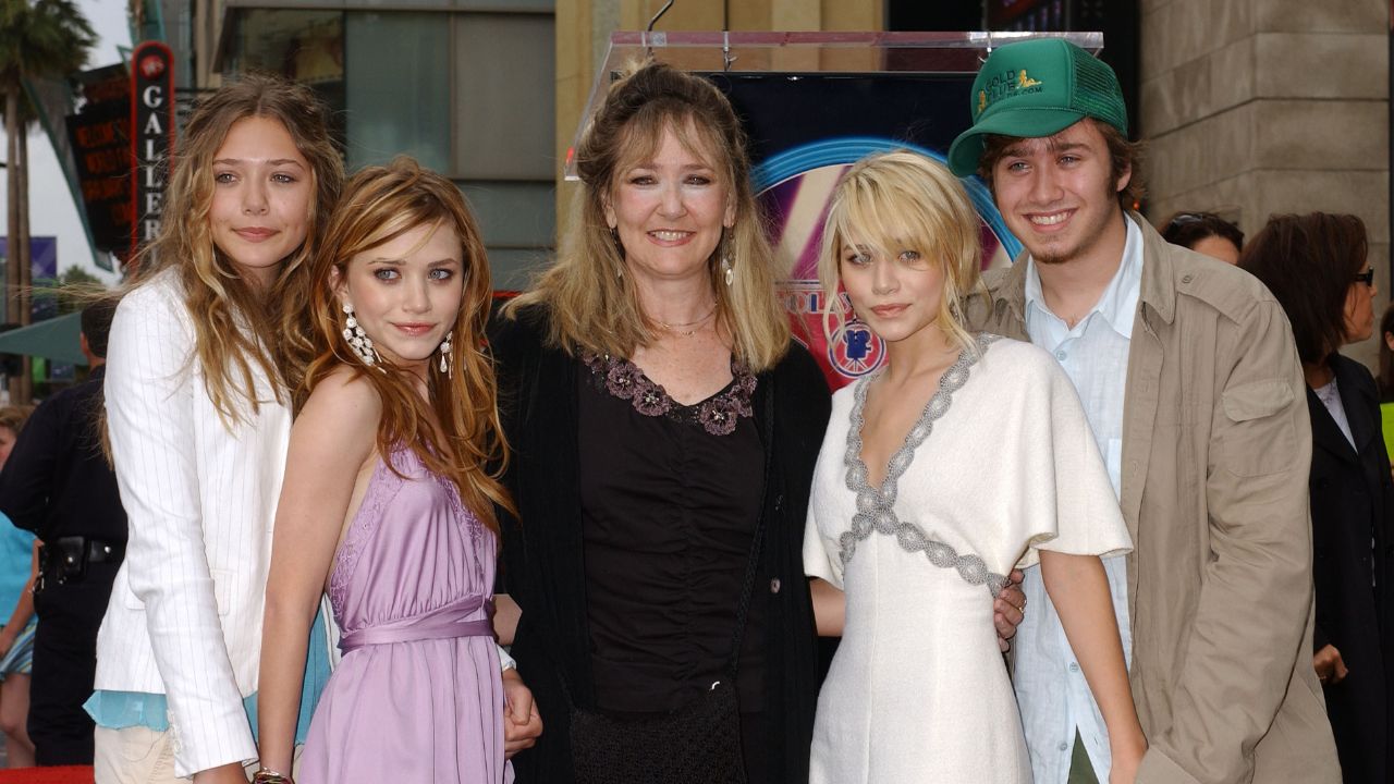 Mary-Kate Olsen and Ashley Olsen with sister Elizabeth (left), mom Jarnette and brother Trent (Getty Images)