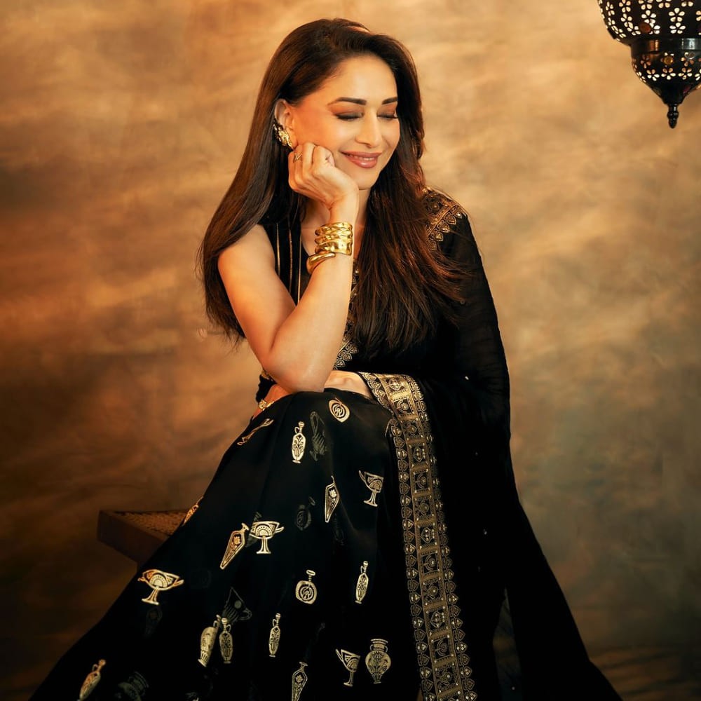 Madhuri Dixit’s black saree balances understated glam with quirky pot accents, creating...